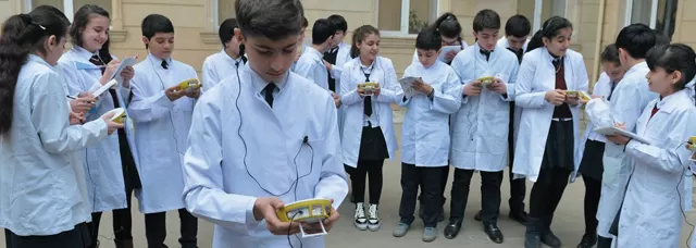 group of students in lab coats using Labdisc Portable STEM Labs