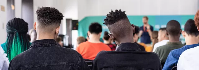 the back of students' heads in a lecture