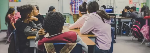 student looking at a teacher in a classroom