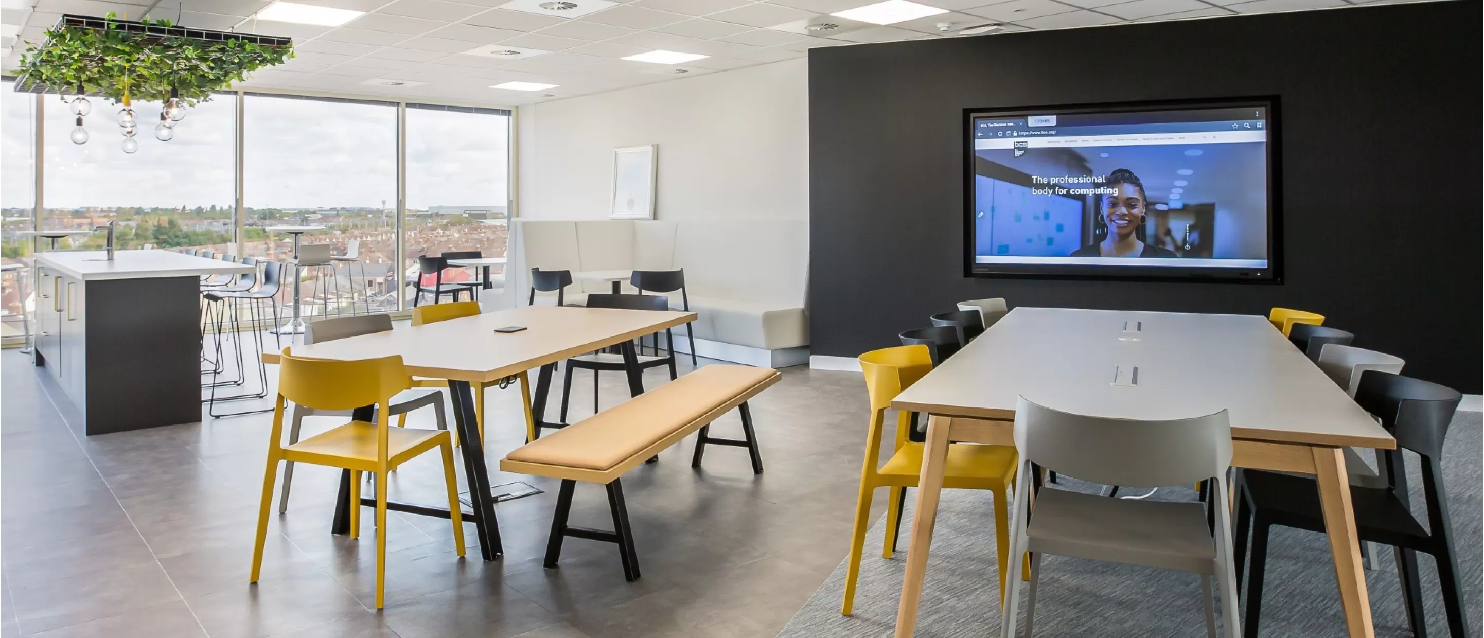 an office kitchen/dinning area with a Clevertouch UX Pro on the wall