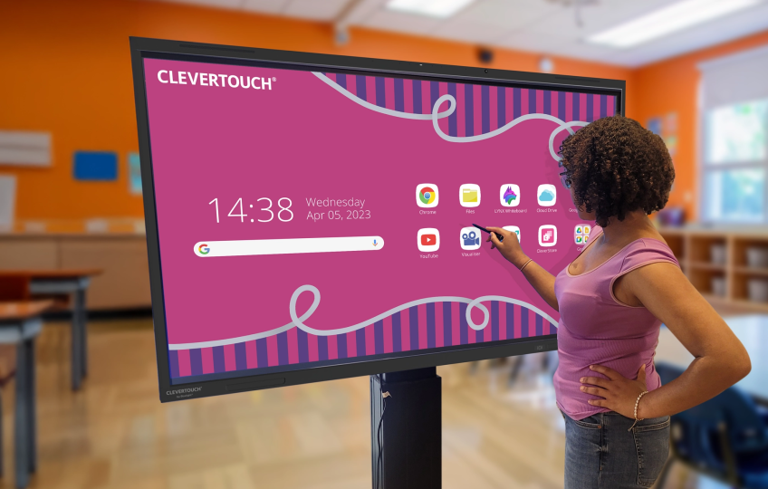 Teacher helping student use an interactive board