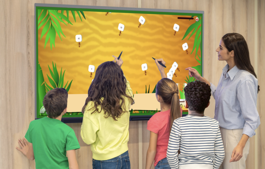 Students using Apps for the classroom on an interactive screen while the teacher helps