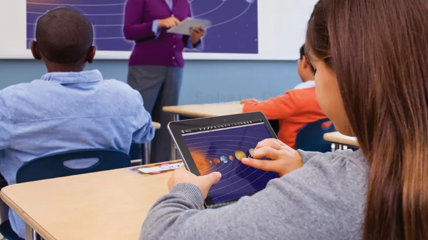 student using MimioMobile App on a tablet with teacher at the front of the class and mimio frame displaying the same thing a the student's tablet