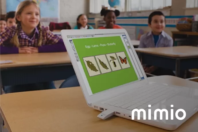 Laptop showing mimio studio with a class in the back ground and 'mimio' in the bottom right corner