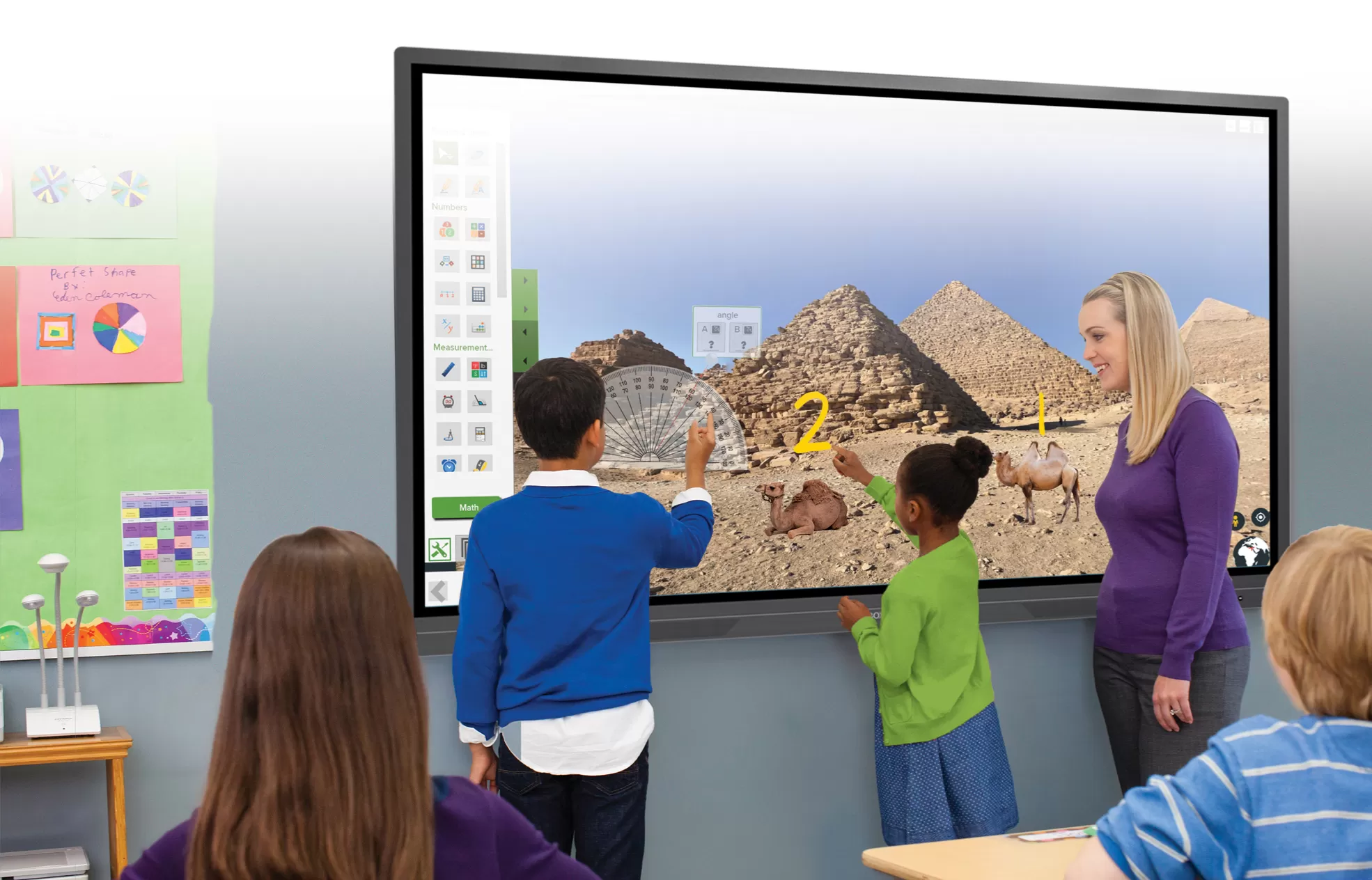 Students using Apps for the classroom on an interactive screen while the teacher helps