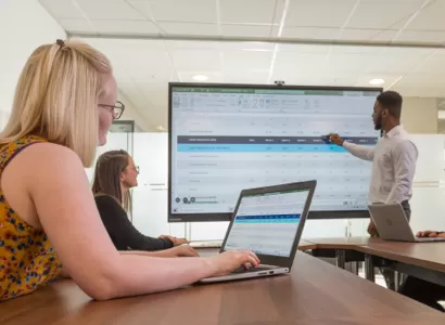 A group using mirroring to share the laptop screen with a large display