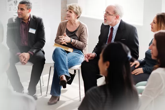 group of people in a circle talking/smiling