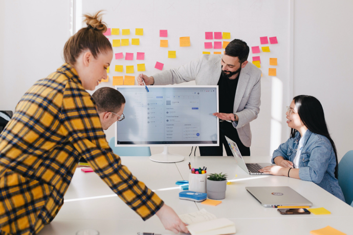 a meeting with everyone looking at a desktop