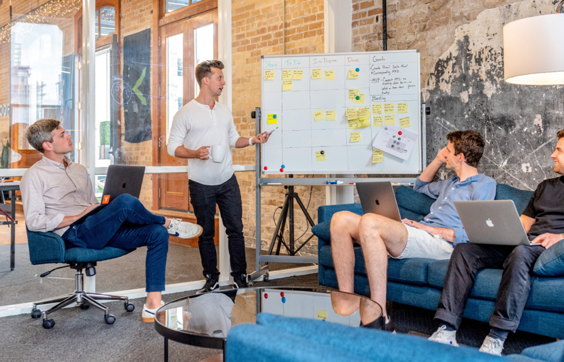 a casual meeting with everyone looking at a whiteboard