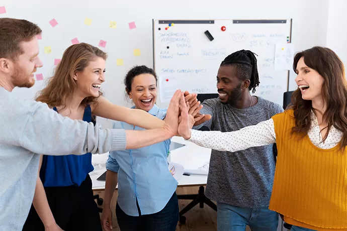 a group of five people high fiving