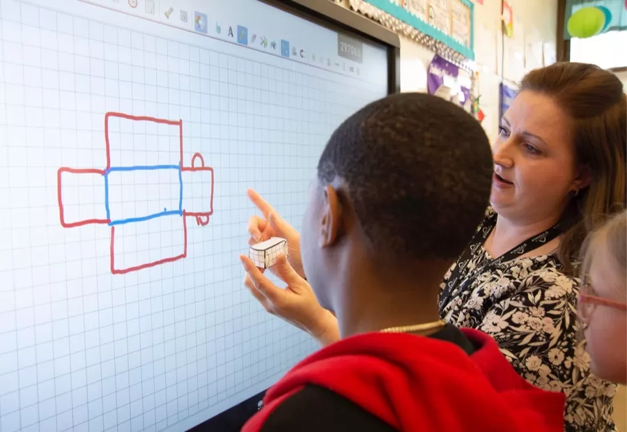 teacher using the display to explain 3d shapes to a student
