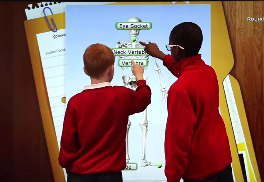 Students using a skeleton game on a large interactive screen