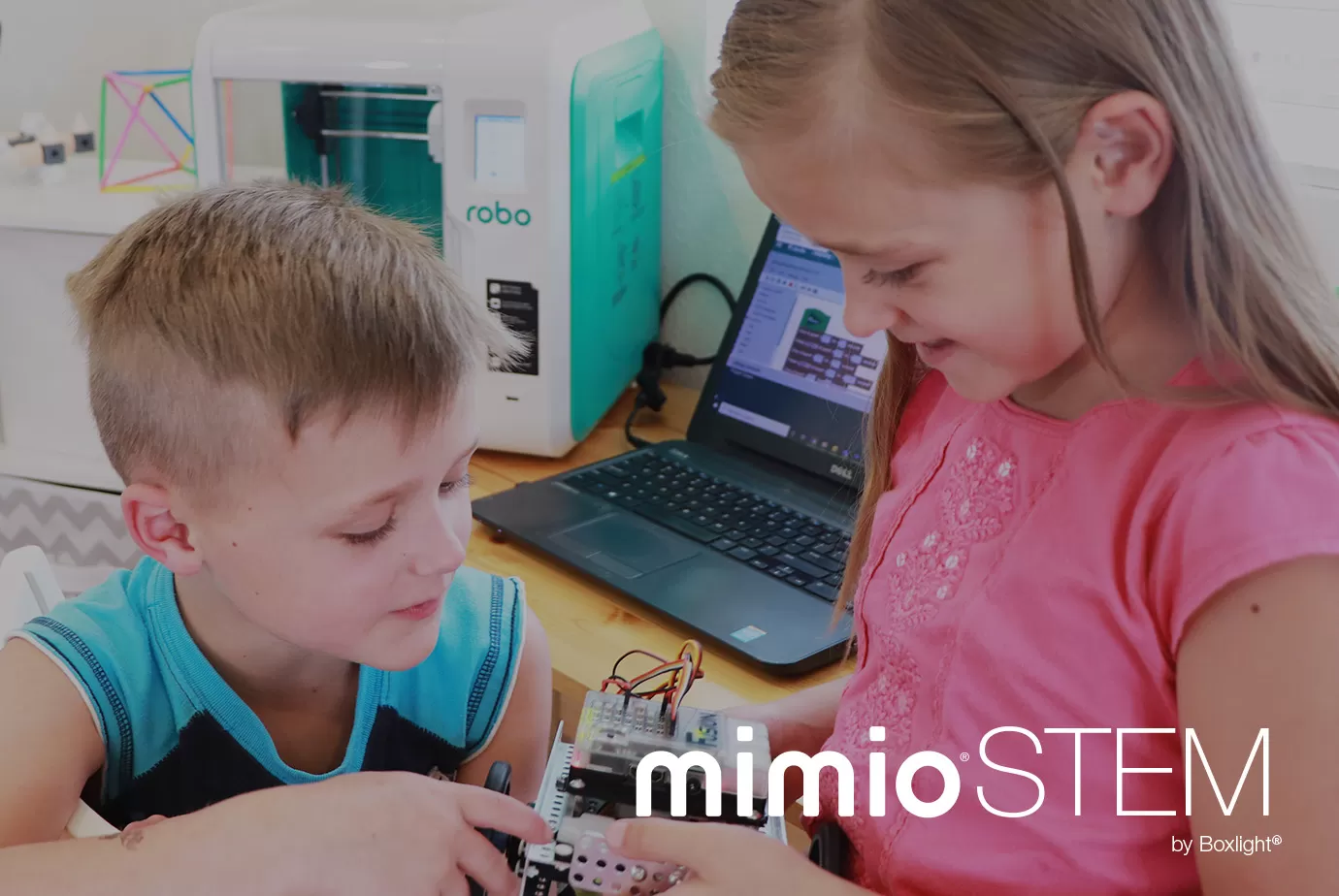 Students looking at Educational Robotics System with MimioSTEM logo in bottom right