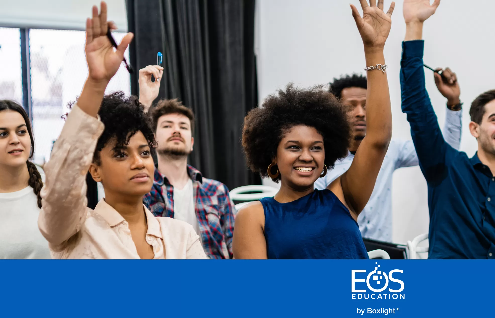 a group of people in a classroom raising their hands with a blue banner and the EOS logo along the bottom