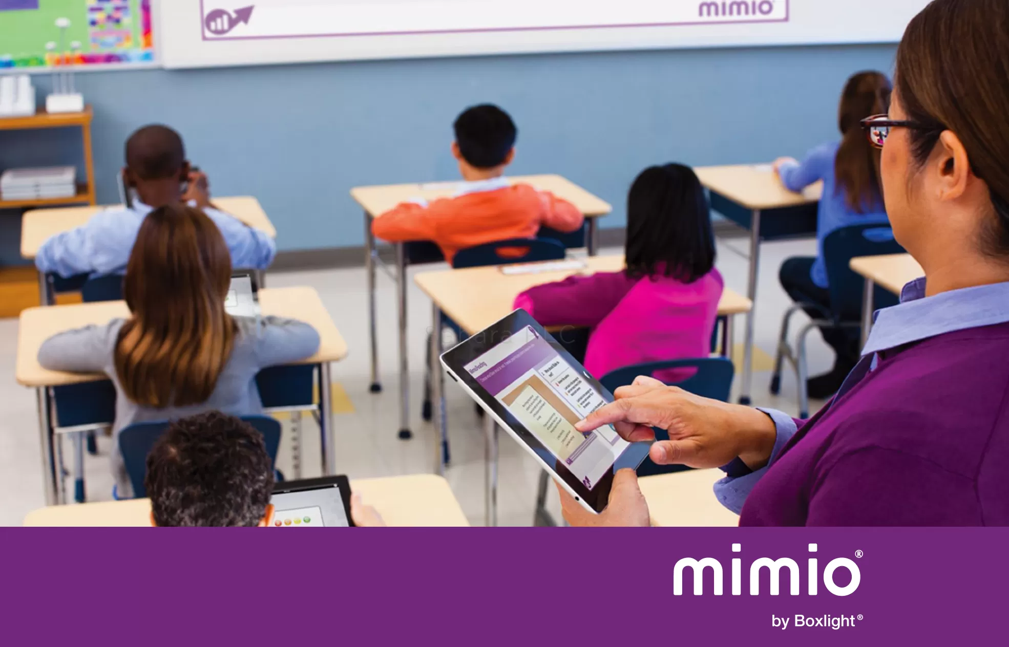 teacher using MimioMobile App on a tablet at the back of the class